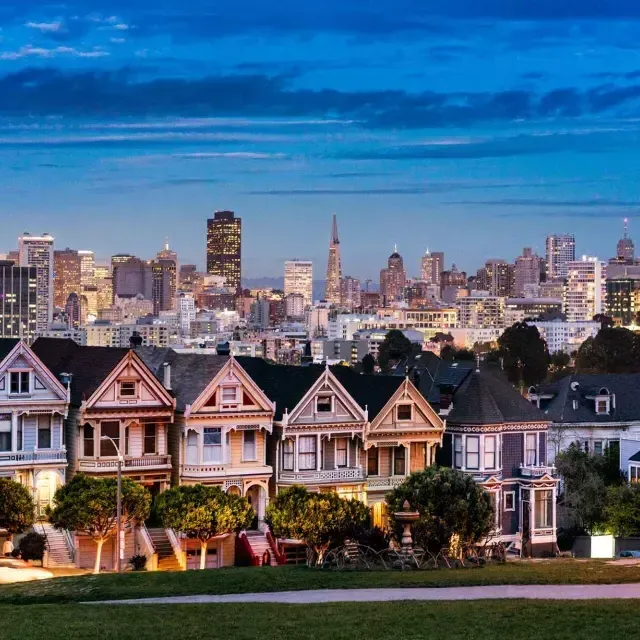 阿拉莫广场(Alamo Square)著名的彩绘女士们在贝博体彩app天际线(贝博体彩app skyline)的黄昏时分被描绘出来.